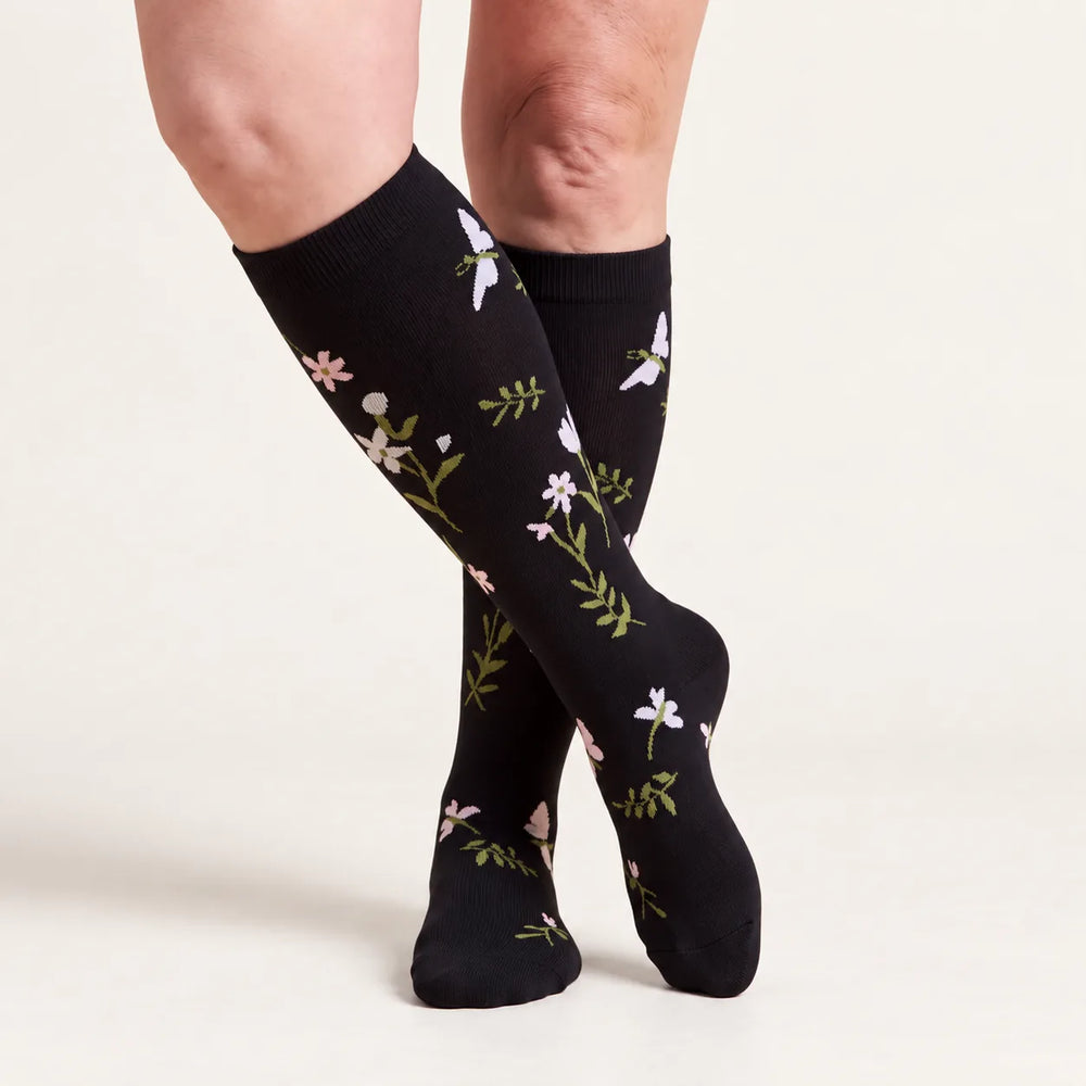 Lovelle Lift compression socks in Black Meadow – knee-high, legs crossed