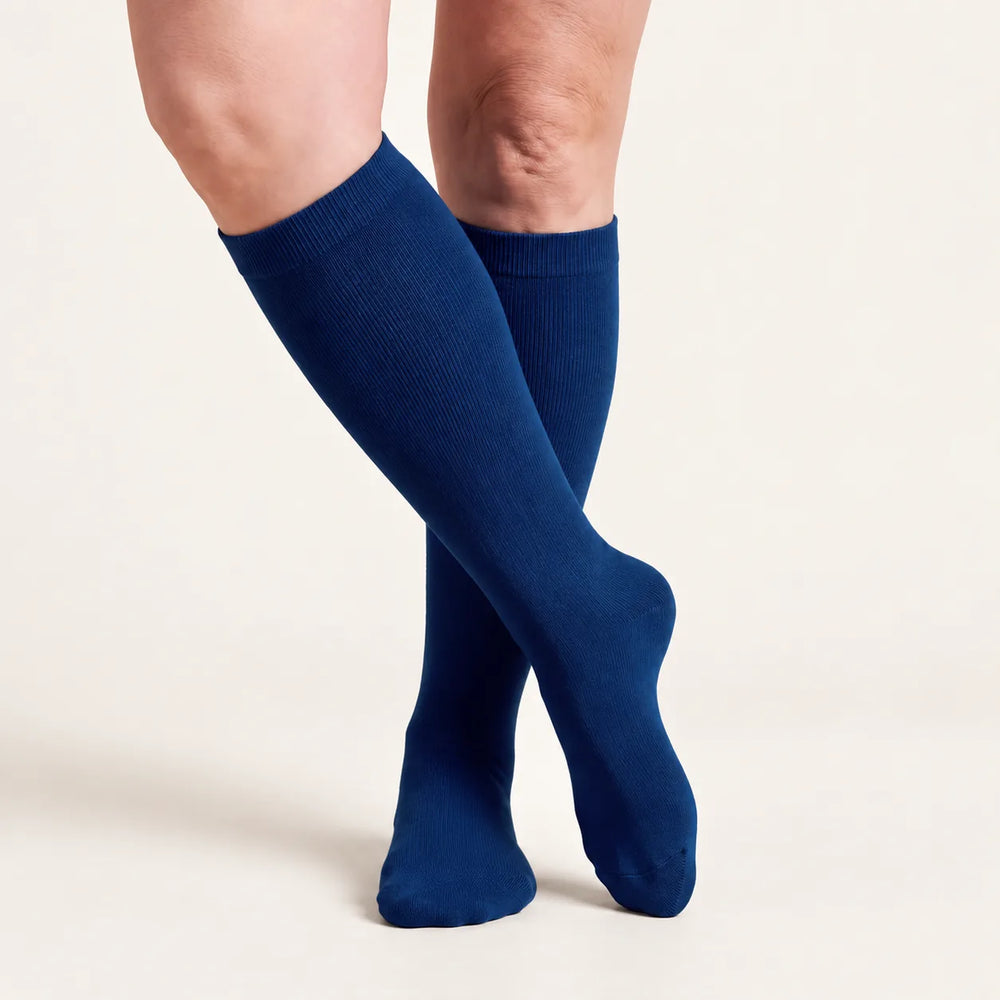 Lovelle Lift compression socks in Navy – knee-high, legs crossed