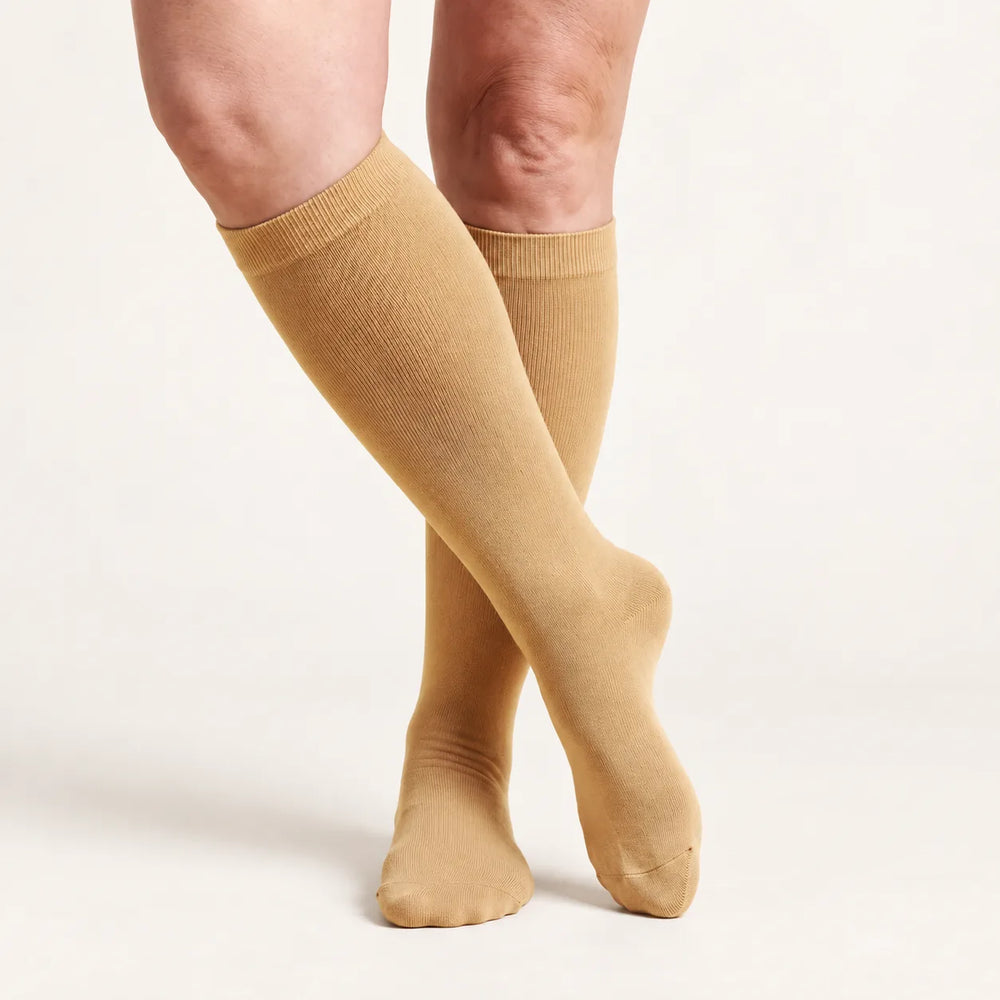 Lovelle Lift compression socks in Sand – knee-high, legs crossed