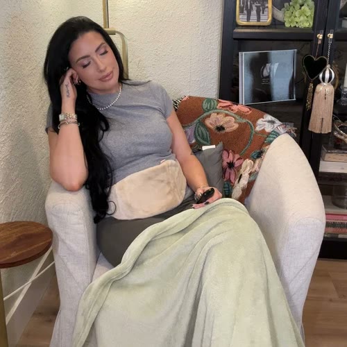 Woman resting in an armchair with Lovelle Hug over her tummy